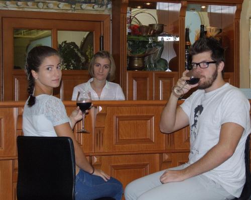 a man drinking a glass of wine next to a woman at Thermal Panzió Sárvár in Sárvár