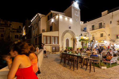 a group of people sitting at tables outside a building at Hotel Seggio in Vieste