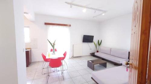 een woonkamer met een bank, een tafel en rode stoelen bij Chania Locals in Chania