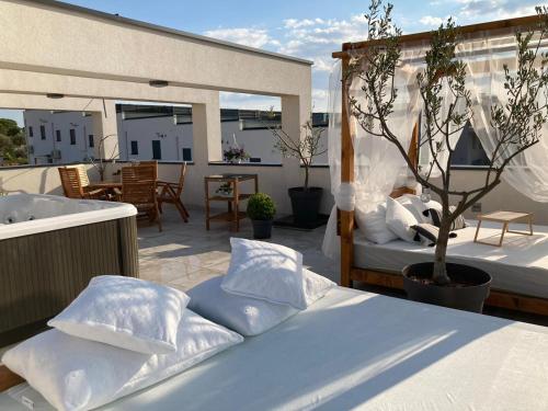a bed with pillows on top of a patio at Rooftop Spa in Trogir