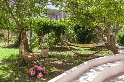 una hamaca en un patio con árboles y flores en Casa Giovanni da Procida, en Procida