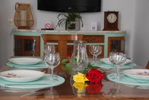 a table with plates and glasses and a clock at Cal Sabater in Preixana