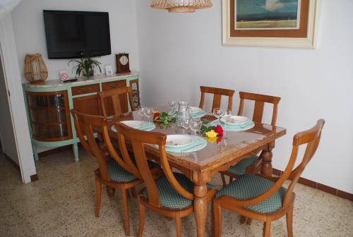 a dining room table with chairs and a television at Cal Sabater in Preixana
