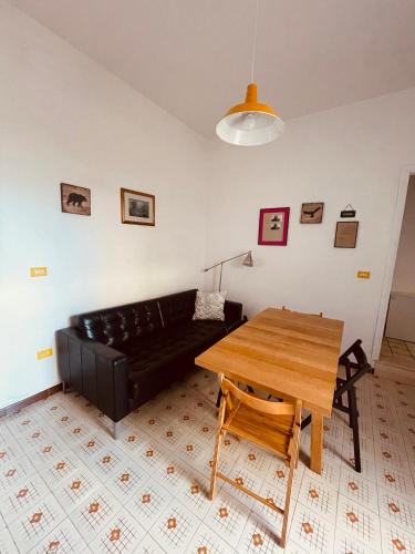 un soggiorno con divano nero e tavolo in legno di Lovely 2 bedroom rental unit,patio and close beach a San Pietro in Bevagna