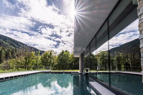 une maison dans les montagnes avec une piscine dans l'établissement Gaia Residence Hotel, à Mezzana