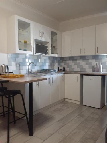 a kitchen with white cabinets and a table with a sink at SixtyB in Despatch