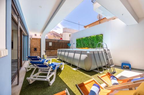 a room with a swimming pool and chairs and a tub at Casa da Vuvu Montes de Alvor in Alvor