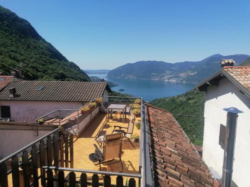 uma varanda com cadeiras e vista para um lago em Casa vacanze 'La piazza' em Zone