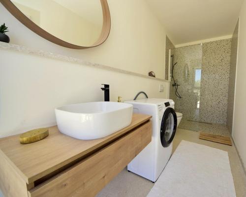 ein Badezimmer mit Waschbecken und Waschmaschine in der Unterkunft BERBA - by Schmidts' in Sutivan