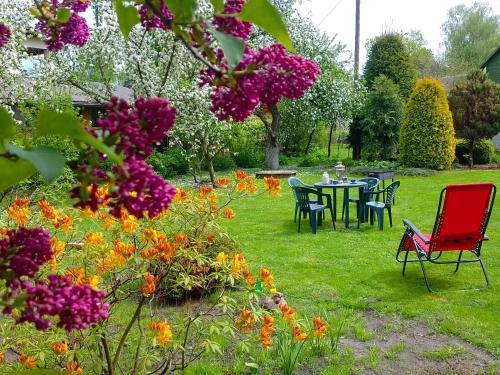 un jardín con mesa, sillas y flores en House, garden & sauna. Free parking. Train stop-200 m. Sea-1 km., en Jūrmala