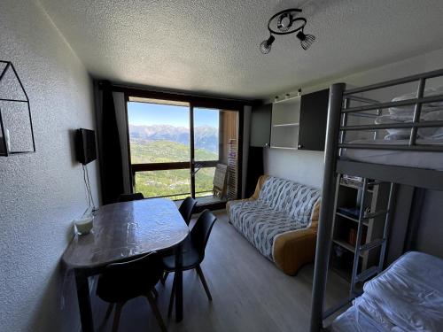 Cette chambre comprend des lits superposés, une table et un lit. dans l'établissement Studio au pied des pistes avec balcon 4/6 pers, à Villarembert