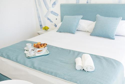 Una cama blanca con una bandeja de comida encima. en Rodi Resort, en Rodi Garganico