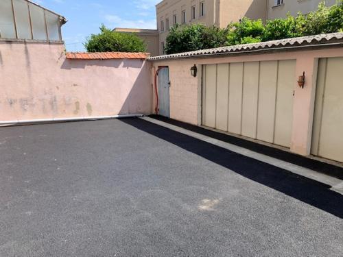 a parking lot with two garages and a building at L'Oasis Appartement Cosy avec Climatisation, Parking, Vélos , Animaux Bienvenus in Châteauroux