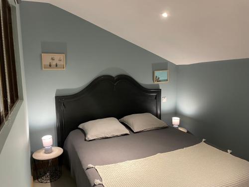 a bedroom with a bed and two candles on tables at Côté Nuit in Capestang