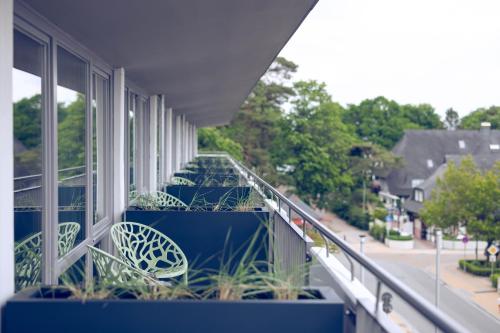 a balcony with chairs and plants on a building at The Flamingo in Timmendorfer Strand