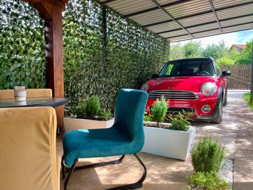 a table and a chair in a patio with a car at Apartment Lena Niksic in Nikšić