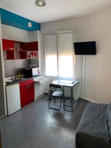 Habitación pequeña con mesa y cocina en Studio 1 tout confort Avec wifi et Netflix, en Valenciennes