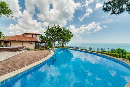 une grande piscine bleue à côté d'une maison dans l'établissement Sunny House Izgrev, à Balchik