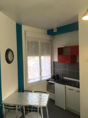 une cuisine avec une table et une horloge au mur dans l'établissement Studio 2, à Valenciennes