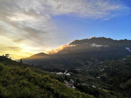 a view of a mountain range with the sun setting at Nulu View Cabin in Kundasang