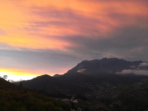 a view of a mountain with a sunset in the background at Nulu View Cabin in Kundasang