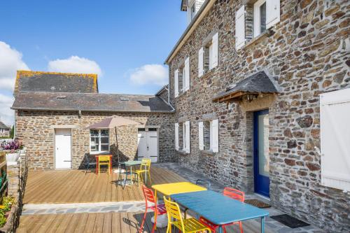 una terraza de madera con mesa y sillas en un edificio en Retour de Pêche - Côté Mer - Belle vue mer, en Saint-Benoît-des-Ondes