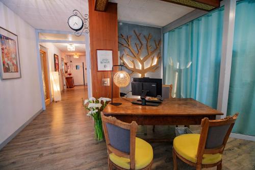 a room with a desk with a computer and chairs at Hostellerie du Parc in Cambo-les-Bains