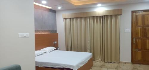 a bedroom with a bed and a window with curtains at ECR River Valley in Kodūr