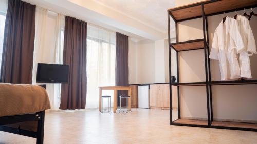 een hotelkamer met een slaapkamer met een bed en een televisie bij Babilon Hotel Tbilisi in Tbilisi City