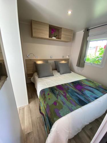 Habitación pequeña con 2 camas y ventana en Mobil home de charme, en Fréjus