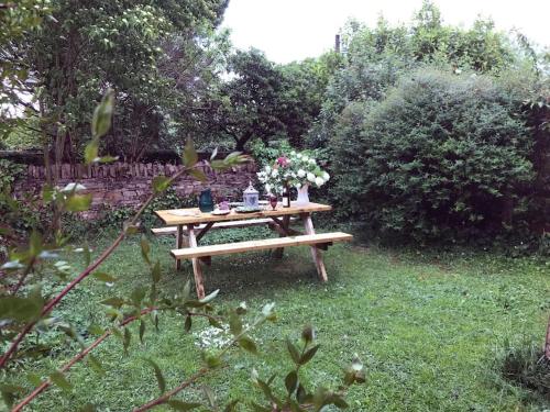 een picknicktafel met bloemen in de tuin bij Hornes Cottage in Longborough