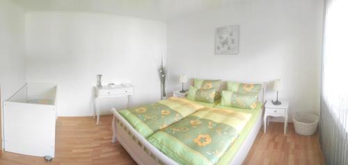 a bedroom with a bed with green and yellow sheets at Ferienwohnung Klötsch in Katzwinkel