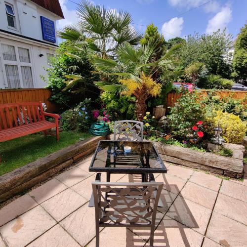 a table and a bench in a garden at Cecil Court Hotel in Bournemouth