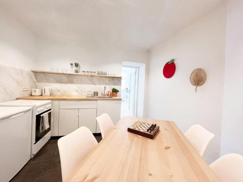 uma cozinha com uma mesa de madeira e electrodomésticos brancos em Central Apartment next to Belvedere Castle em Viena