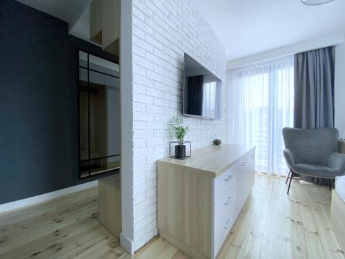 a living room with a dresser and a chair at Willa Lazur ADULTS ONLY in Międzyzdroje