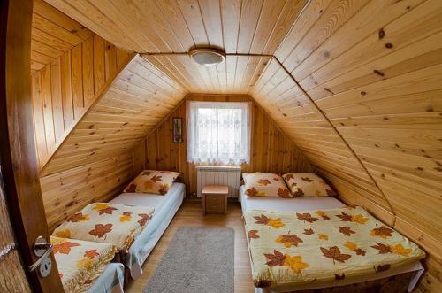 Habitación con 2 camas en una cabaña de madera en Agroturystyka Nad Tanwią, en Biszcza