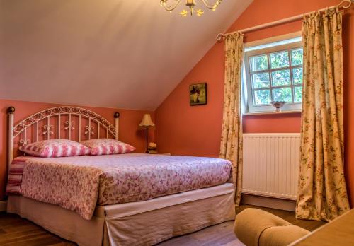 een slaapkamer met een bed en een raam bij Vakantiehuis Aen de Roderburgh in Maaseik