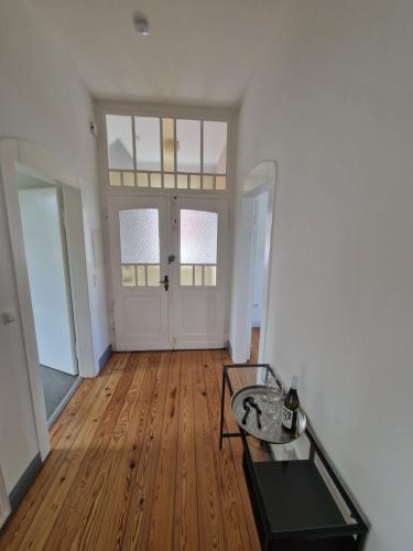 an empty living room with a table and wooden floors at Stylisches Apartment in Hohenlimburg in Hagen