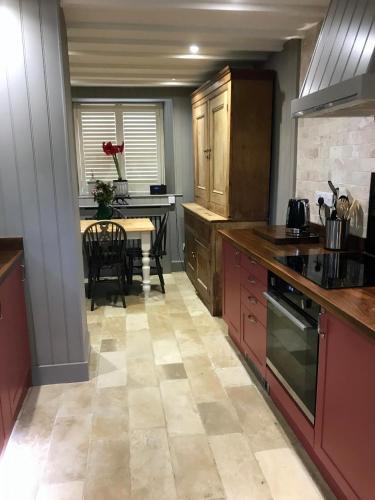 a kitchen with a table and a dining room at Hornes Cottage in Longborough