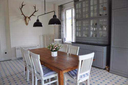 a kitchen with a wooden table and white chairs at Villa Osterloff in Oderberg