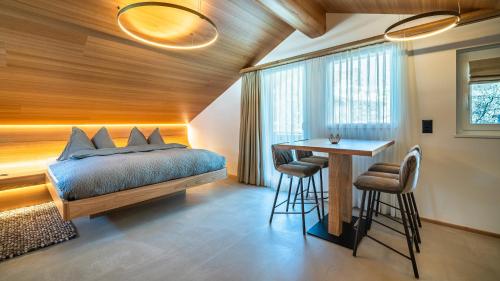 een slaapkamer met een bed en een tafel met krukken bij Boutique Hotel La Gorge in Saas-Fee