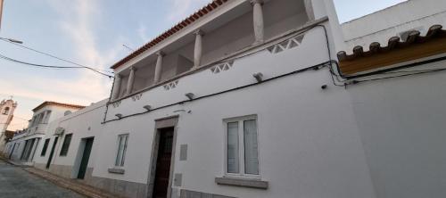 un bâtiment blanc avec un panneau sur son côté dans l'établissement Casa Al'entejo, à Ferreira do Alentejo