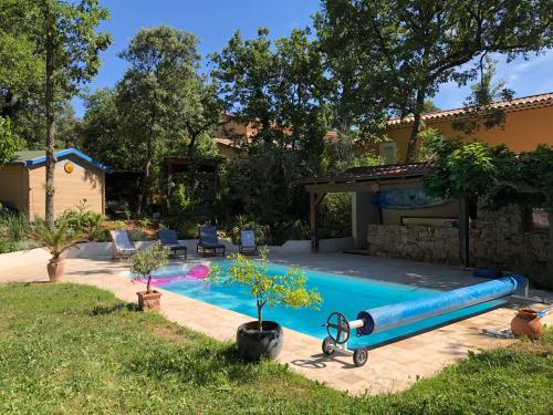 uma piscina num quintal com um insuflável azul em Dépendance individuelle em Nans-les-Pins