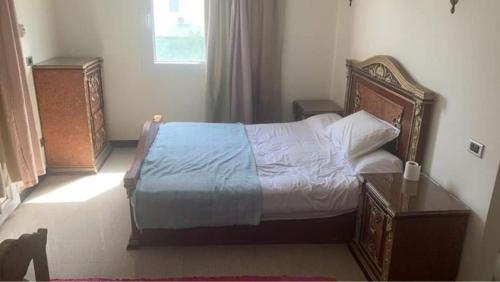a bedroom with a bed with a wooden headboard at North coast Sedra Resort Chalet قريه سيدرا الساحل الشمالي علي البحر شاليه ثلاث غرف in Alexandria