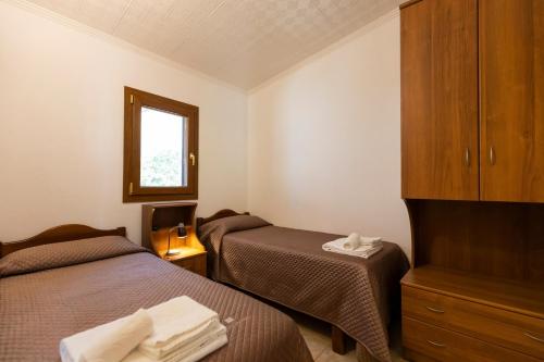 a hotel room with two beds and a mirror at Villaggio Tramonto in Capo Vaticano