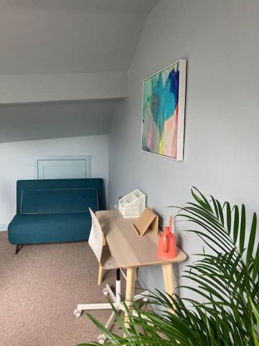 a living room with a blue couch and a table at The Wild Daisy in Barnoldswick