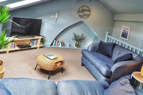 a living room with a couch and a tv at The Wild Daisy in Barnoldswick