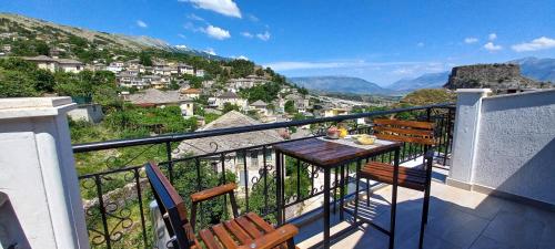 a balcony with a table and chairs and mountains at KALE GUESTHOUSE in Gjirokastër