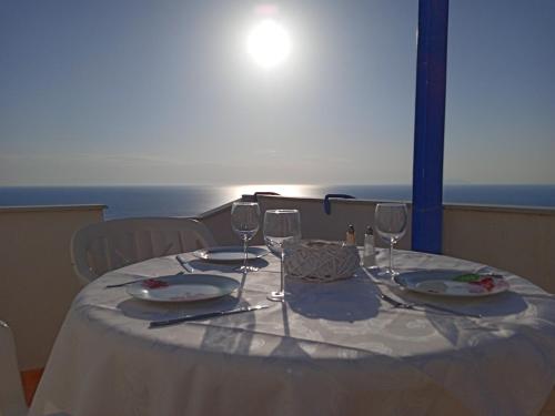 a table with a white table cloth and wine glasses at Mastiha luxury maisonette II in Líthion