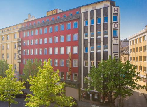 a red building in the middle of some buildings at NP Hotel Königshof in Dortmund
